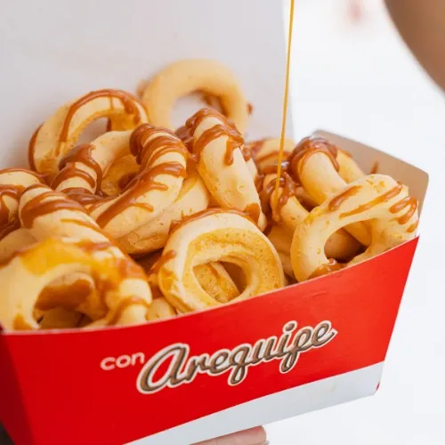Cajita de rosquillas recién horneadas bañadas en arequipe